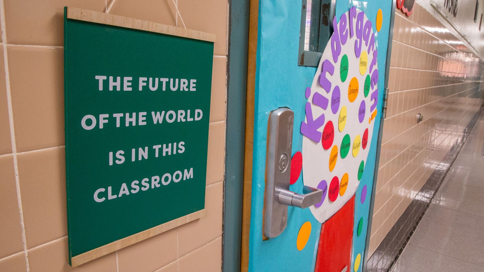 A sign outside a kindergarten classroom reads, "The future of the world is in this classroom."