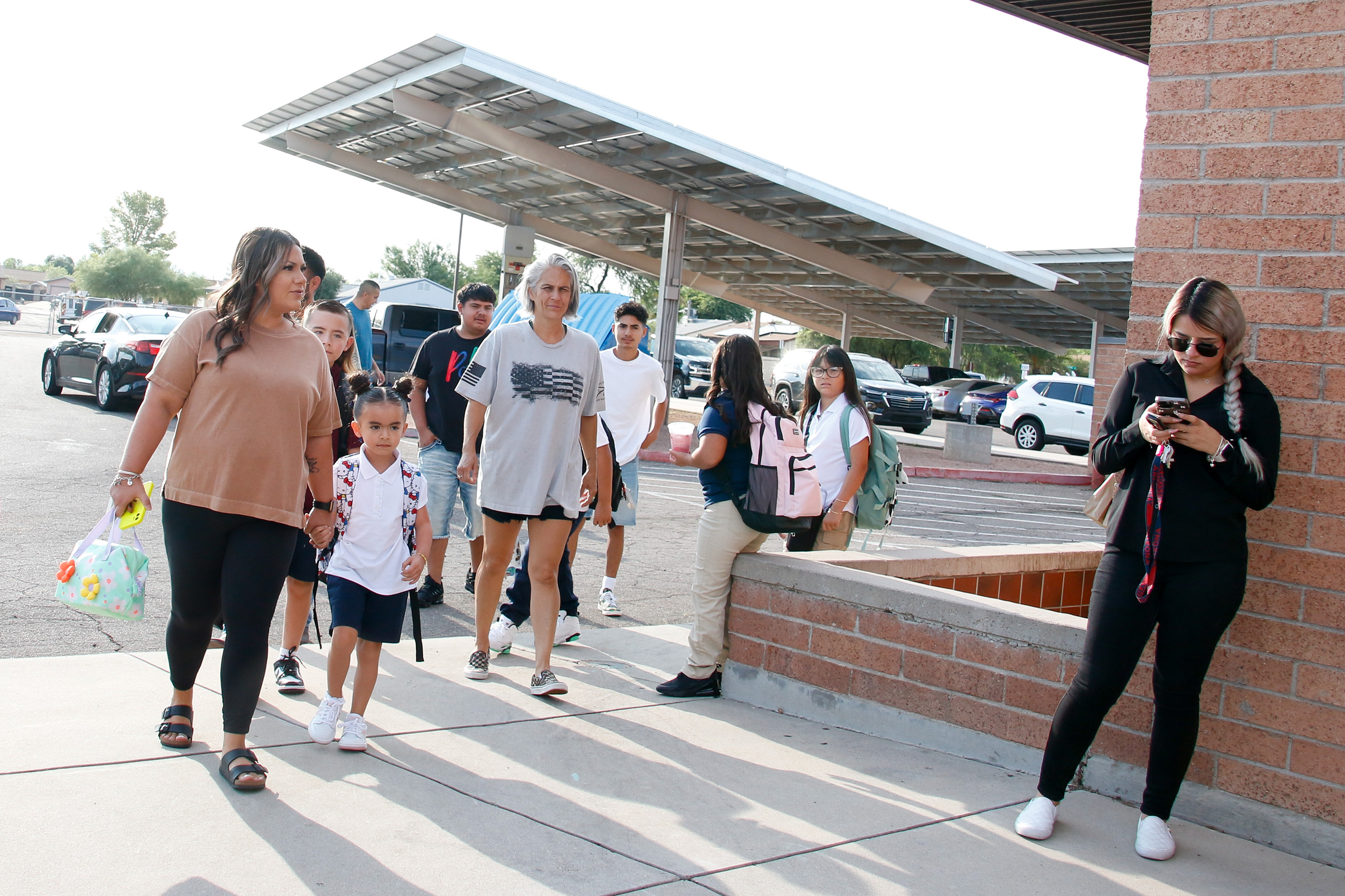 Students walk in with their parents on the first day of school