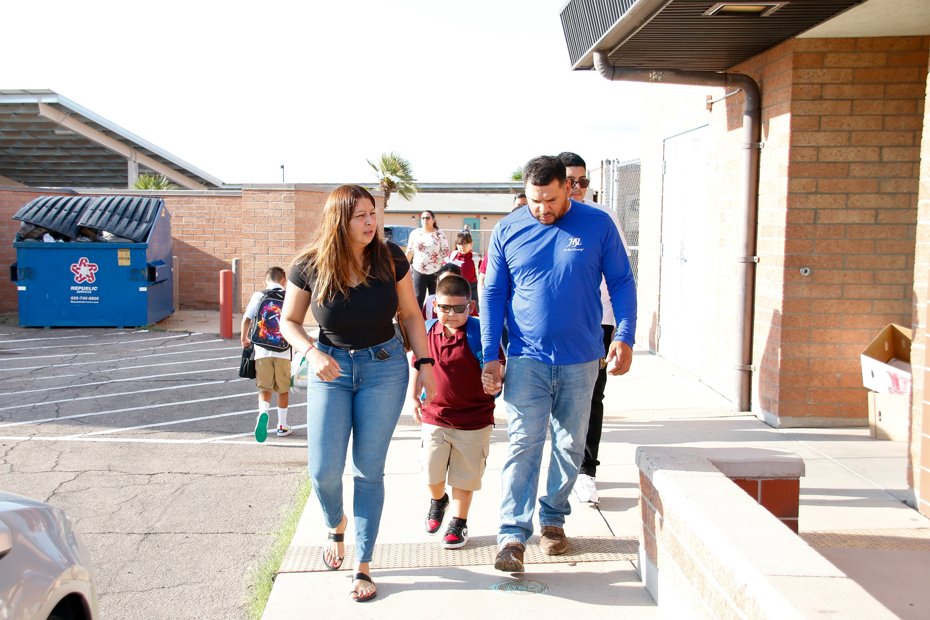 Students walk onto campus with their parents on the first day of school