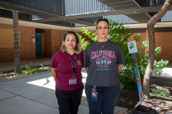 Two women stand outside the school
